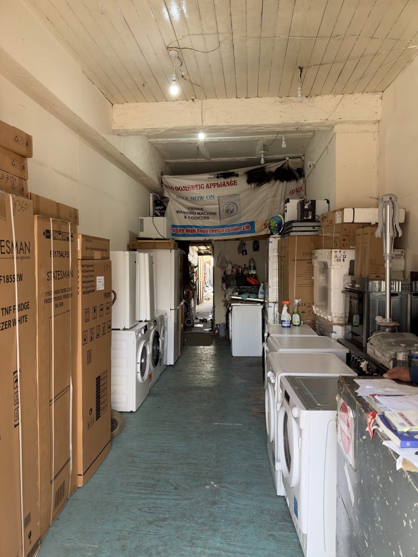 Inside the E10 Domestic Appliances shop on Leyton High Road, shelves and floor stocked with washing machines, dryers, fridges and cookers